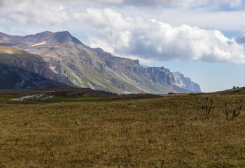 a trail on a rocky mountain plateau located on the path of a tourist route with an overview of the area