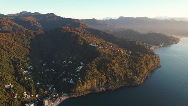 Mountains background with blue sea. Drone footage of green mountains.