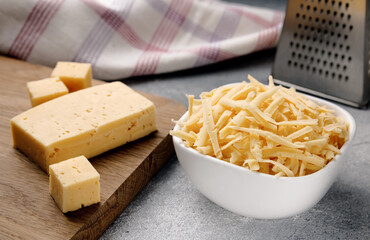 Grated cheese and grater. Concept: Italian cuisine, cheese, restaurant, and food.