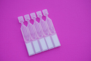 Single use artificial tear lubricant eye drops containers, tubes, isolated on pink  background....