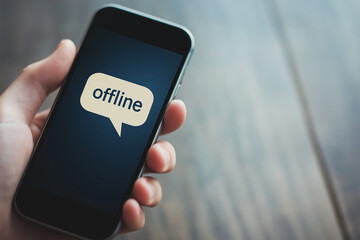  documentary style image of a hand holding smartphone with "offline" speech bubble, minimal background, digital disconnection concept