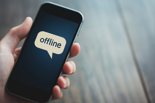  documentary style image of a hand holding smartphone with "offline" speech bubble, minimal background, digital disconnection concept