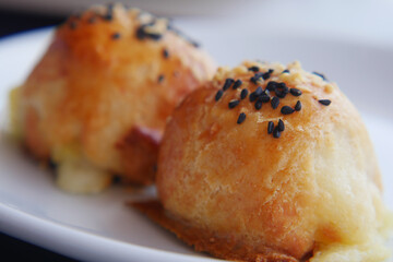 Delicious baked dumplings with sesame seeds served on a plate