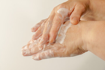 Fototapeta premium close-up of a woman's hands rubbing a white cream on her hands