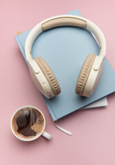 Wireless headphones resting on books with coffee nearby, embracing relaxation and productivity