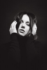 Portrait of a woman with dark hair, done in low key style.