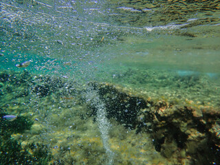 Ocean blue underwater with sunrays, Underwater Sea Deep Water Abstract Sunshine, sea wave , clean waters in summer time, Natural underwater seascape, sand on ocean floor and water surface with sunligh