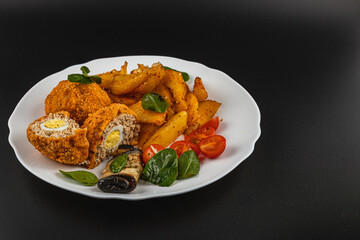 Crispy stuffed chicken dish served with seasoned potato wedges and vegetables