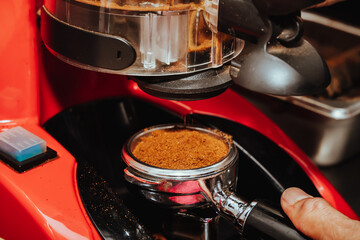 photo of ground coffee falling from grinder into filter of espresso machine in Colombian coffee shop