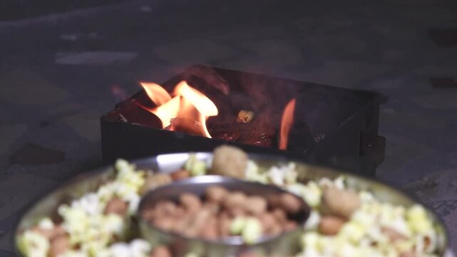 popcorn, sesame candy and roasted groundnuts and burning flame in the background
