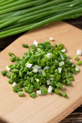 heap of green chopped onions on wooden table.