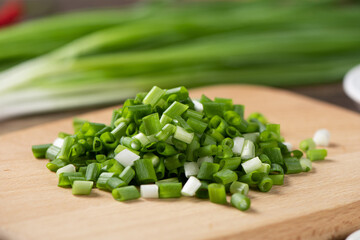 heap of green chopped onions on wooden table.