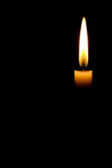 Burning candle on black background with space for text. For themes related to remembrance, mourning, loss or spirituality, hope and keeping the fire of life burning.