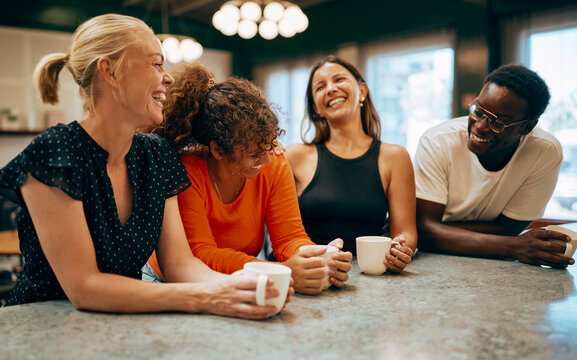 Happy Group Of Diverse Friends Laughing Together Over Coffee At Cafe