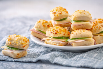 Small sandwiches with hamp and cheese as appetizers on a plate