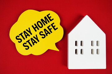 Stay Home Stay Safe text message on speech bubble with house model on red background