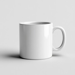 Fototapeta premium A plain white ceramic mug with a C shaped handle sits on a light gray surface, illuminated by soft, even lighting.