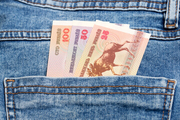 Old Belarusian ruble in the pocket of blue jeans