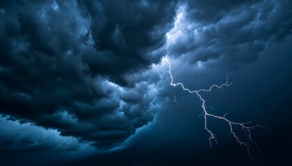 A summer thunderstorm with heavy rain gusty winds and flashes of lightning brightening the dark clouds. Fierce storm bright sky.