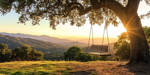 A wooden swing hanging from a sturdy oak tree, overlooking a quiet valley as the sun sets behind distant mountains. 
