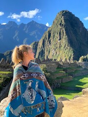 Woman in peruvian poncho looking on Machu Picchu Peru. 