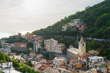Fototapeta premium Riomaggiore’s Charm: Colorful Homes and Vineyard-Covered Hills