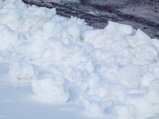 A snowbank of plowed snow in the sunshine