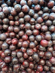 Plum black harvest from China  sell at the market. Blackthorns background
