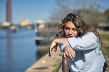 Portrait of young, beautiful, blonde woman, wearing a shirt, posing looking at infinity, angry and...