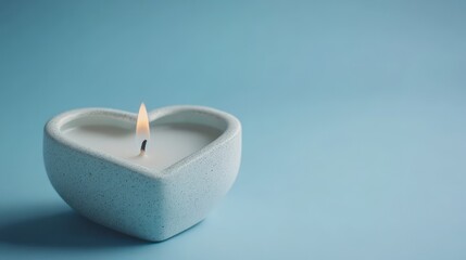 A heart shaped candle with an illuminated and flickering flame