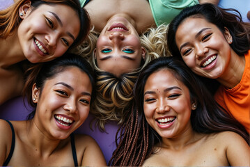 Fototapeta premium Group of Happy Young Women Lying in Circle Smiling and Enjoying Friendship