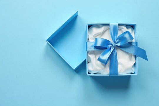 A light blue gift box with a satin ribbon bow rests on a matching background, partially open to reveal soft white interior