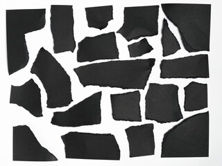 Set of irregularly torn black pieces of paper, isolated on white background.