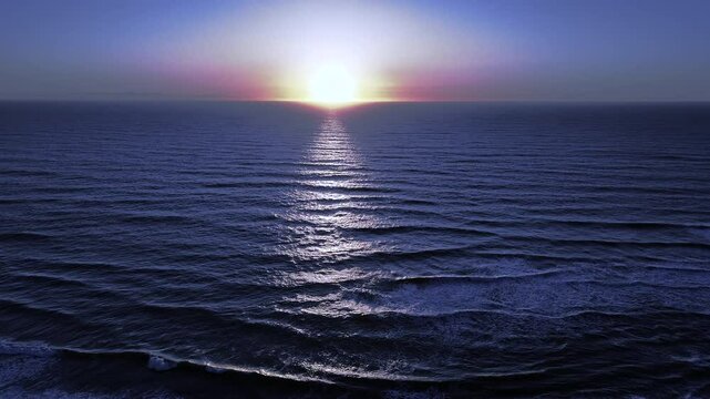 Cool-toned sunset over calm ocean waves with layered ripples and soft light reflection at dusk, captured by drone in a tranquil and atmospheric seascape under a fading sky. 