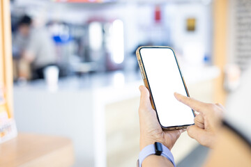 Woman holding a smartphone with a blank screen at a restaurant