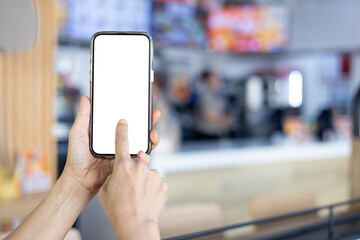 Woman holding a smartphone with a blank screen at a restaurant