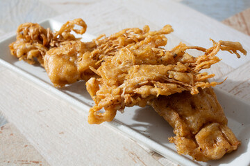 A view of a plate of fried enoki.