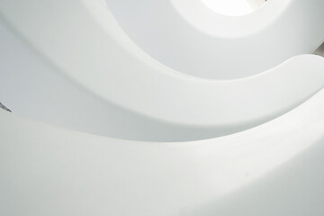Abstract view of white spiral staircase with smooth curves and geometric patterns in The Museum of the Future, bottom view. Modern interior design in Dubai city, United Arab Emirates. View from below