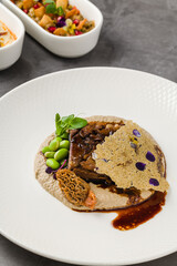 Gourmet plate of slow-cooked meat, morel mushrooms, puree and tuile