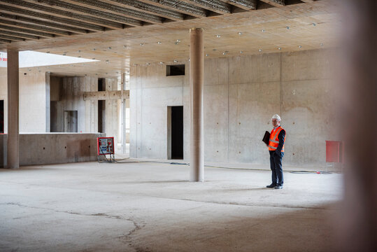 Engineer inspecting a shell construction site wearing a safety vest and hard hat