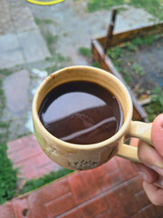 beautiful cup of coffee in hands. unusual cup. clay cup of tea. man drinking coffee. man drinking tea. live camera.