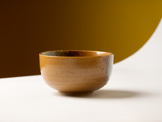 An empty bowl is placed on the white floor table in the kitchen.