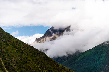 Picturesque mountain landscape. View of the mountain in the snow, covered with fog. Colorful travel background