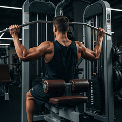 muscular man lifting weights. close up of Shoulder pull down machine. Fitness man working out pulldown training at gym.