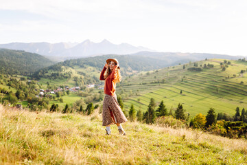 Portrait of a smiling woman having fun on a green lawn. Beautiful traveler in a hat enjoying sunny weather. Concept of beauty, relaxation, freedom.