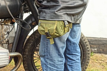 one military green cloth with zipper and plastic buckles small with straps personal bag hanging on...