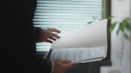 Suited man quietly reviews documents inside a secret folder. The scene suggests discretion, classified information, or covert activity— Espionage, corporate intrigue, or internal investigations. spy