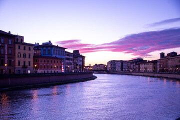 Naklejka premium Pisa's iconic blend of history and art, reflected in the gentle flow of the Arno river