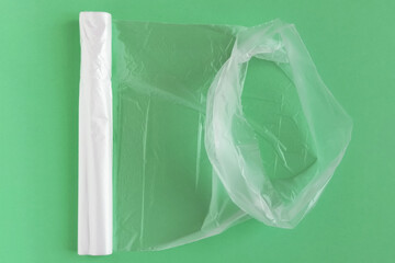 Transparent polyethylene bags in an unrolled roll. Green background.