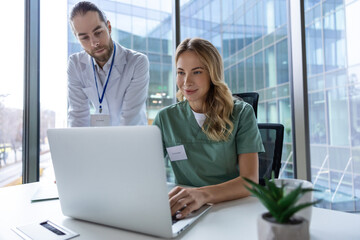 Doctor in hospital sitting at desk working on laptop